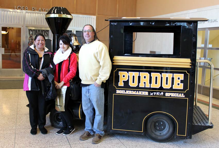 student and parents pose for picture by the Boilermaker special