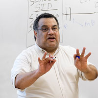 Roy Dejoie, teaching in front of a whiteboard