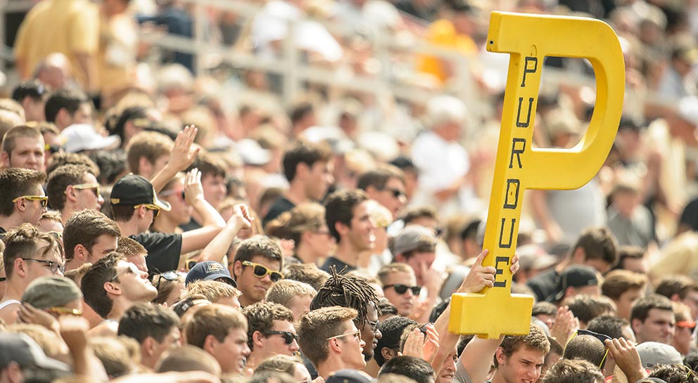 students at a football game holding a Purdue P sign together