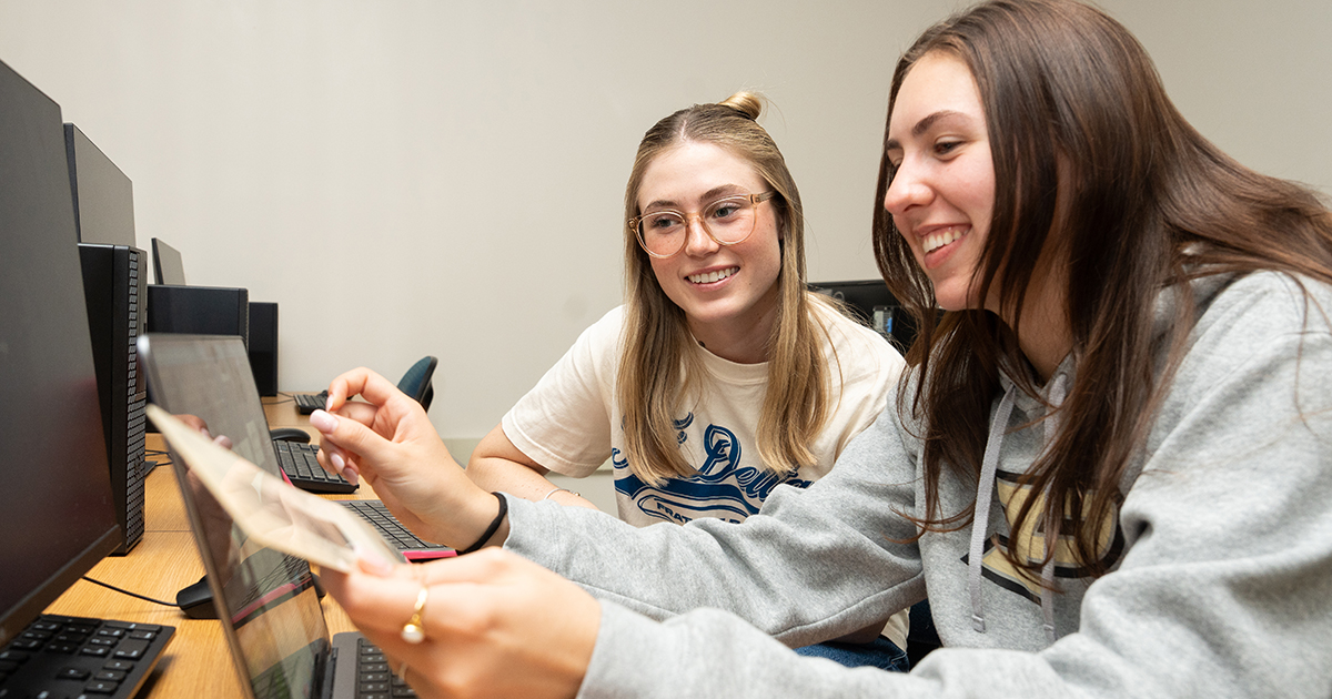Two students collaborate on graphic design