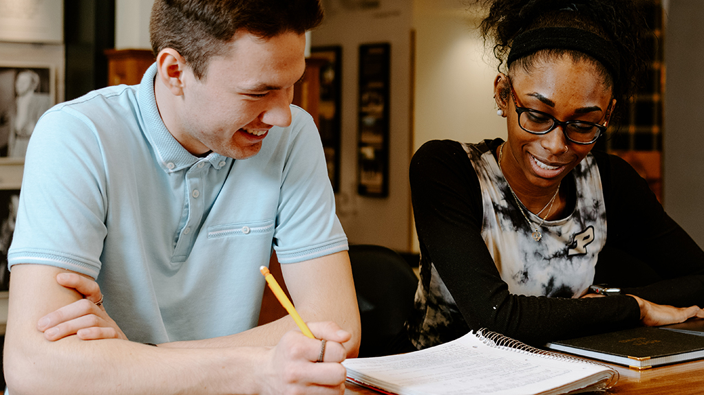 Two students study together at a table