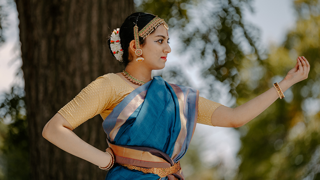 A student performs a dance at an outdoor cultural event