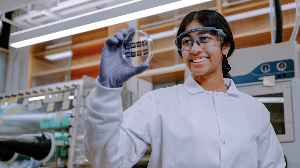 An engineering student holds up a sample