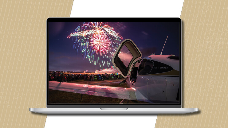 Landed aircraft with fireworks going off in the background.