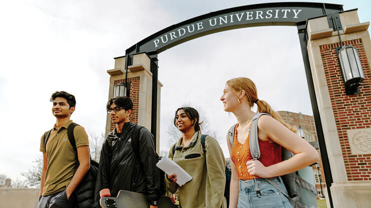Students walking under the Purdue University arch in West Lafayette.