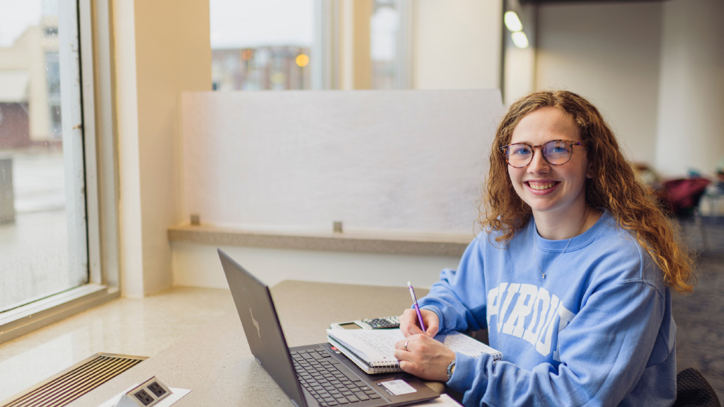 Accounting student at computer smiling