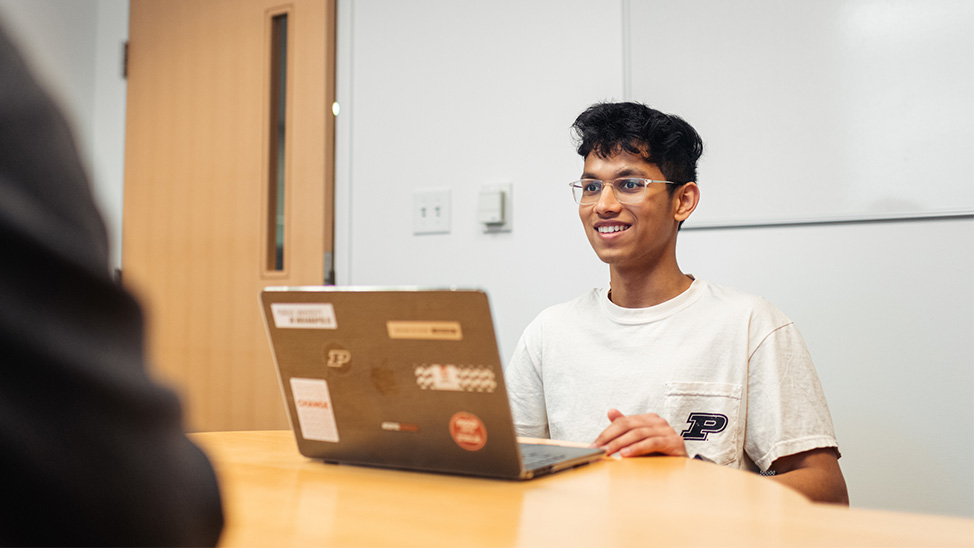 CS Student Nikhil smiling at lap top