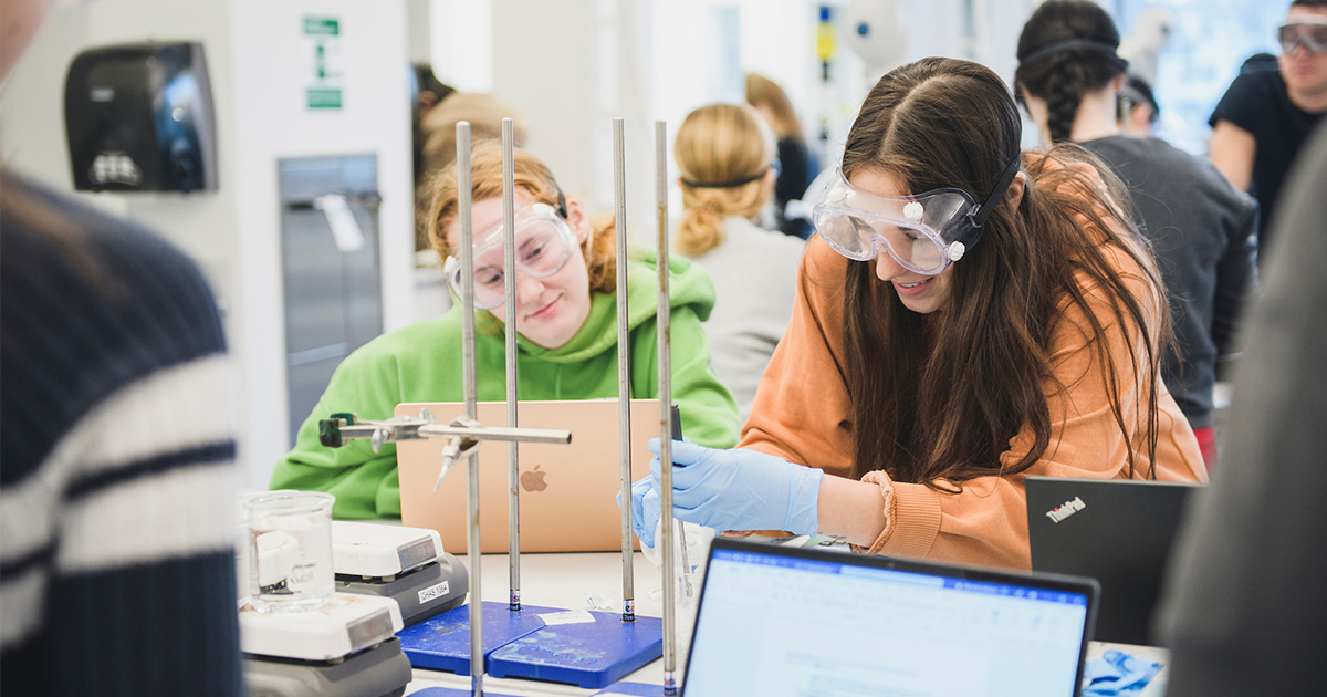 two girls examining work in chemistry lab