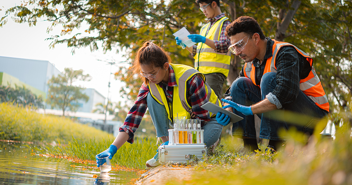 Students and an advisor collect samples from a pond