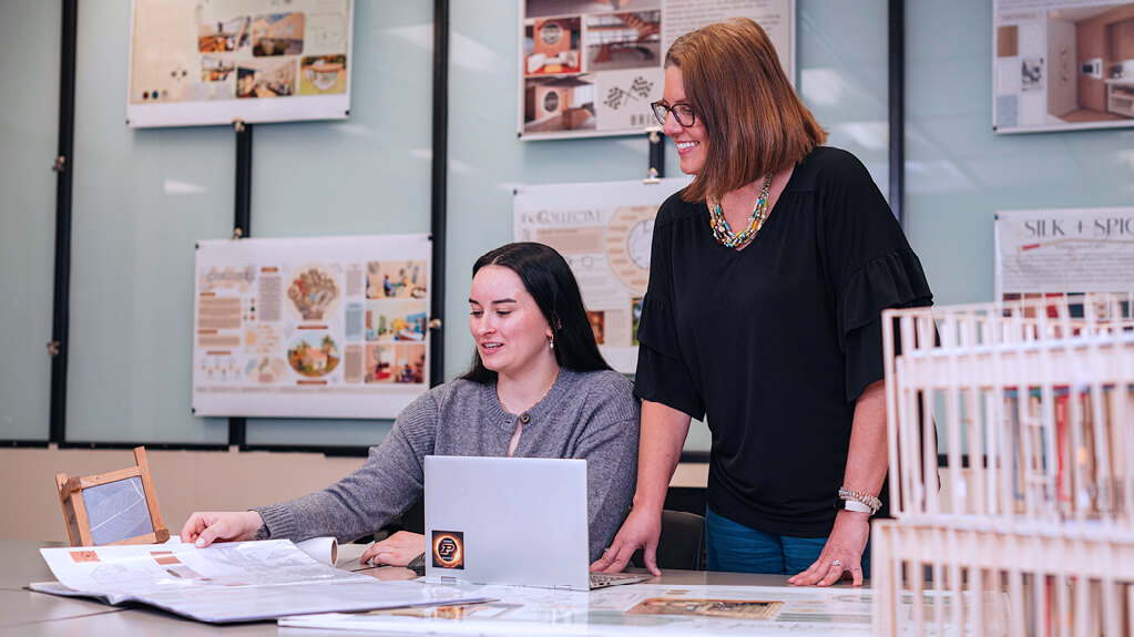 A student discusses a project with an instructor