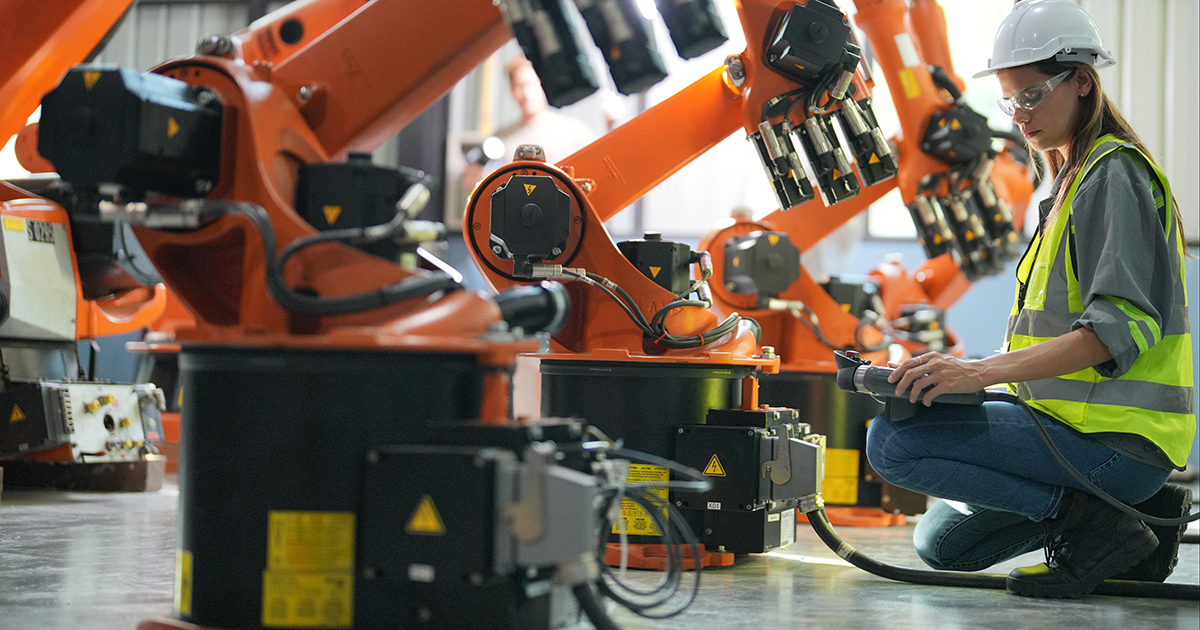 A student works on industrial robotic machinery
