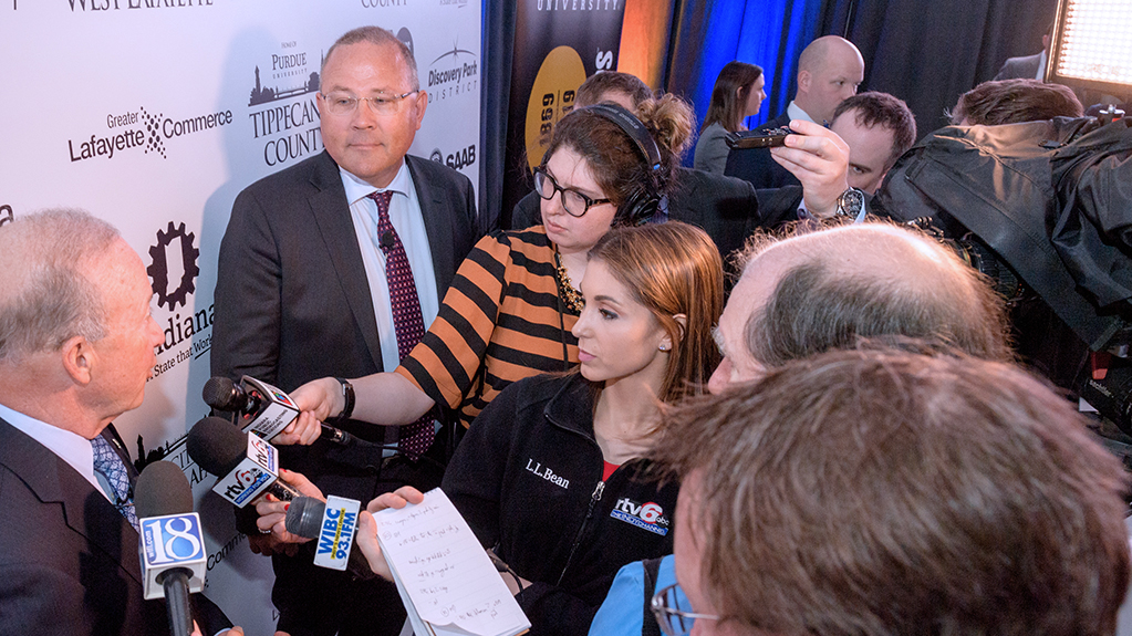 News teams interview hold up the microphones during an interview