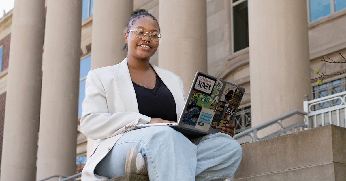 A student works on her laptop as she sits outside of a courthouse