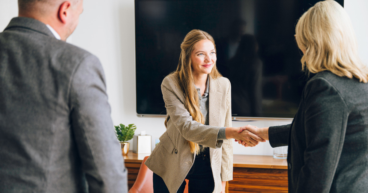 Management student shaking hands with a professional