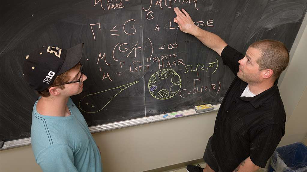 math instructor working out math problem with student