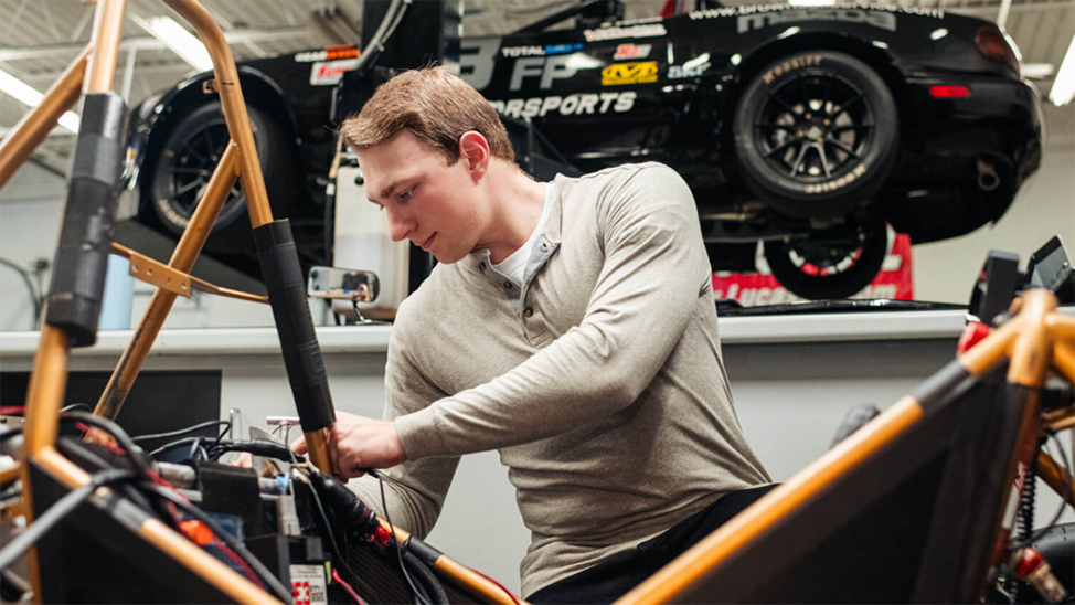 Reed England works on a car frame