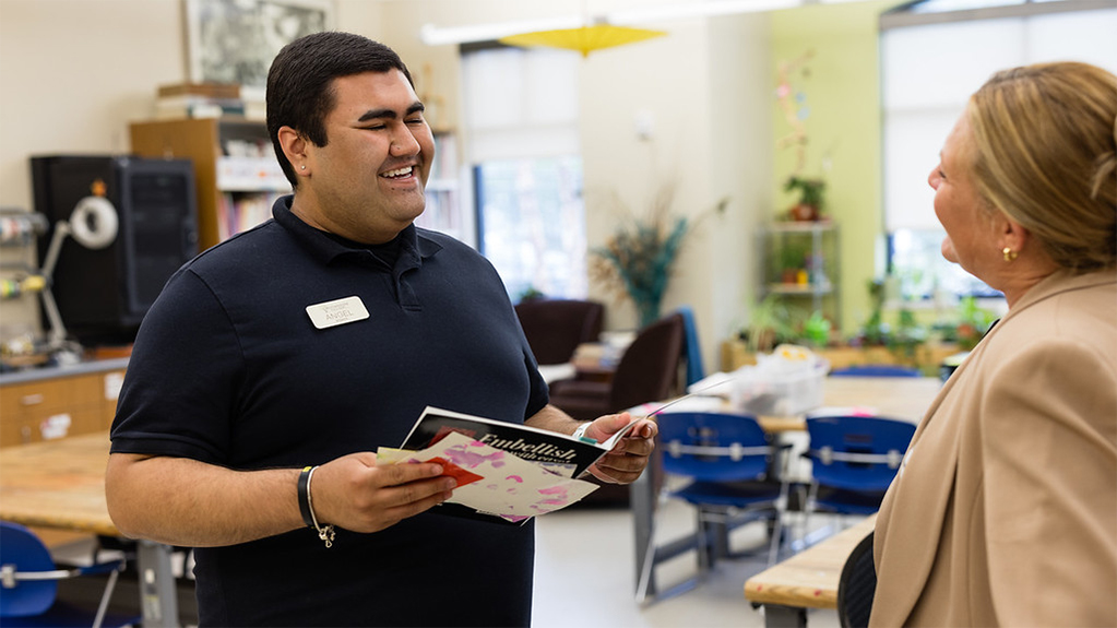 Two professionals interact in a classroom setting
