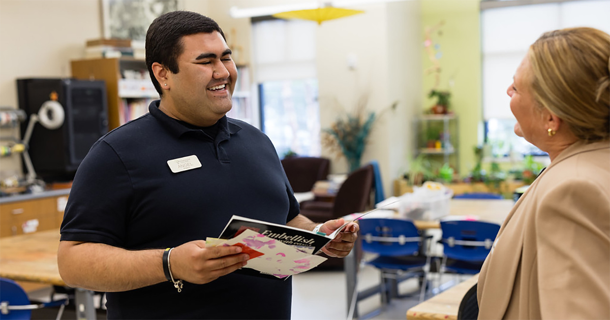 Two professionals interact in a classroom setting