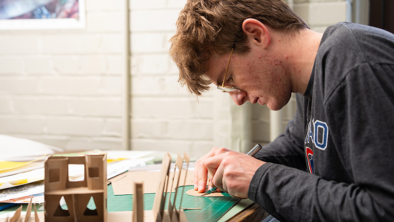 A student cuts shapes for a paper model