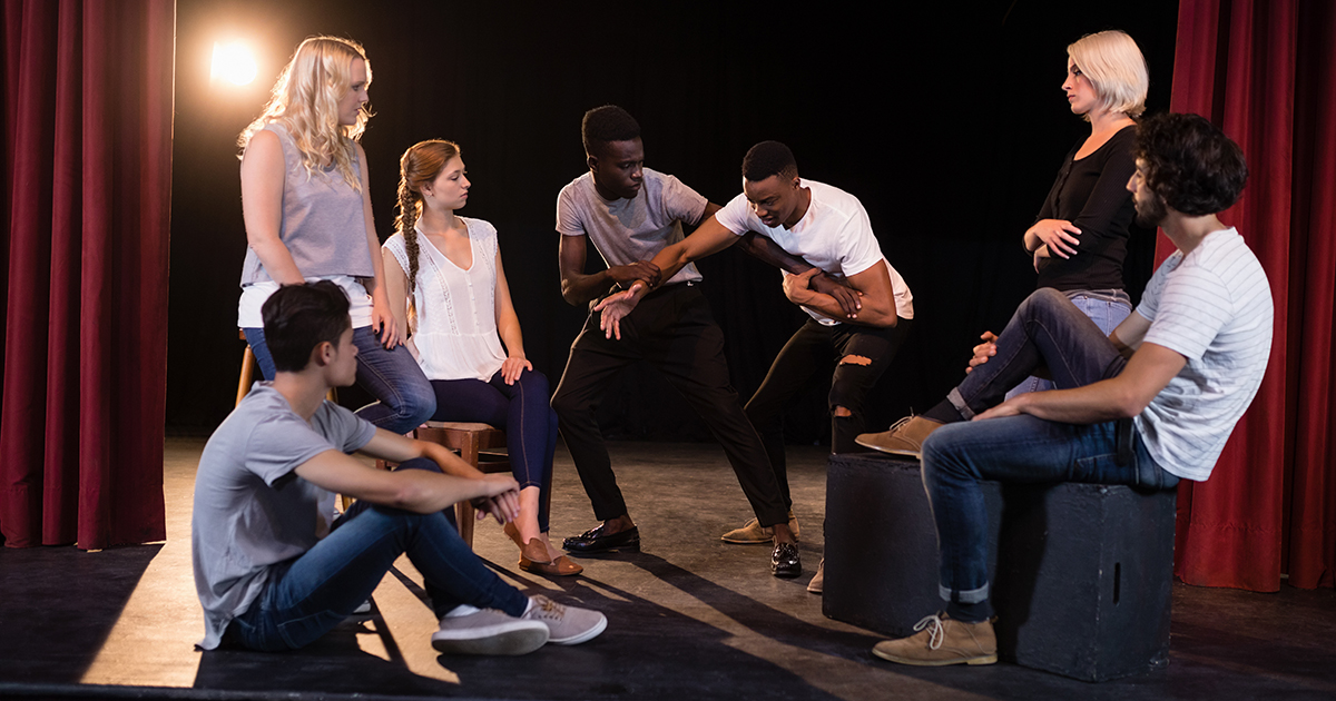 Students practice for a play on stage