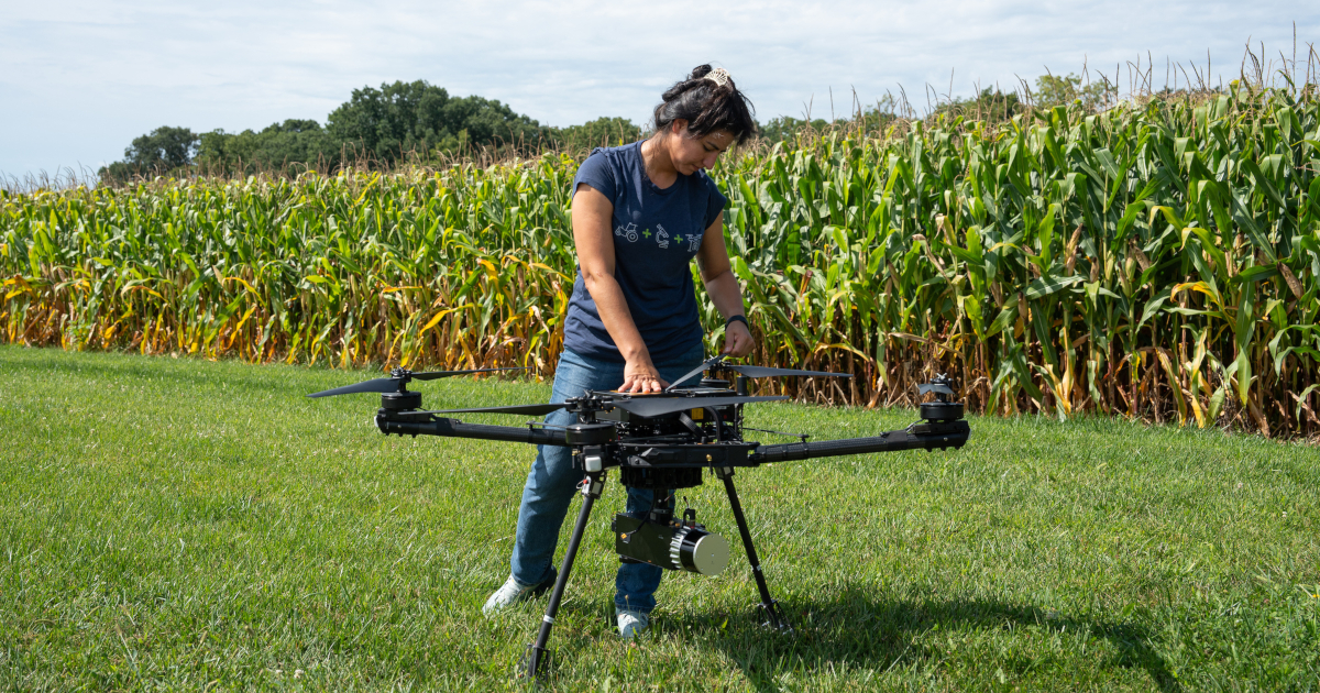 Person stands in front of cornfield with unmanned aerial vehicle
