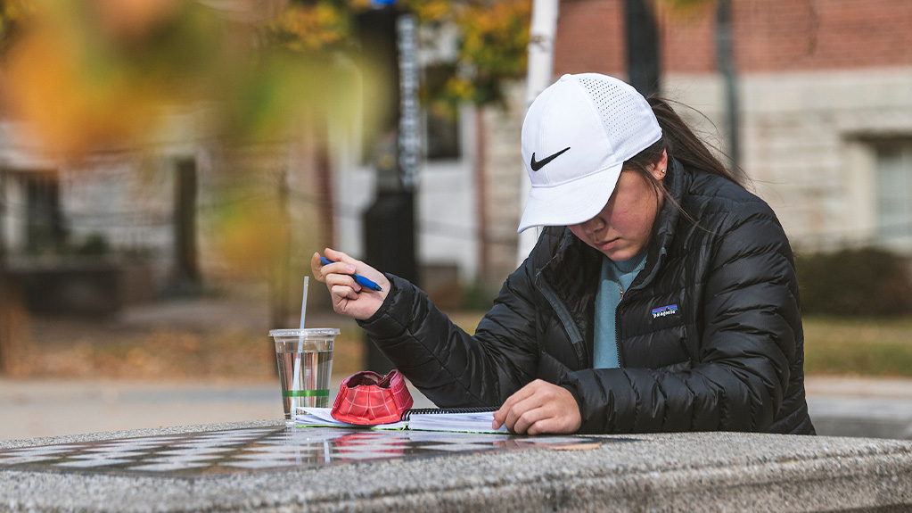 girl studying at table outside.