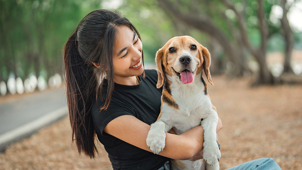 Woman smiles holding a beagle