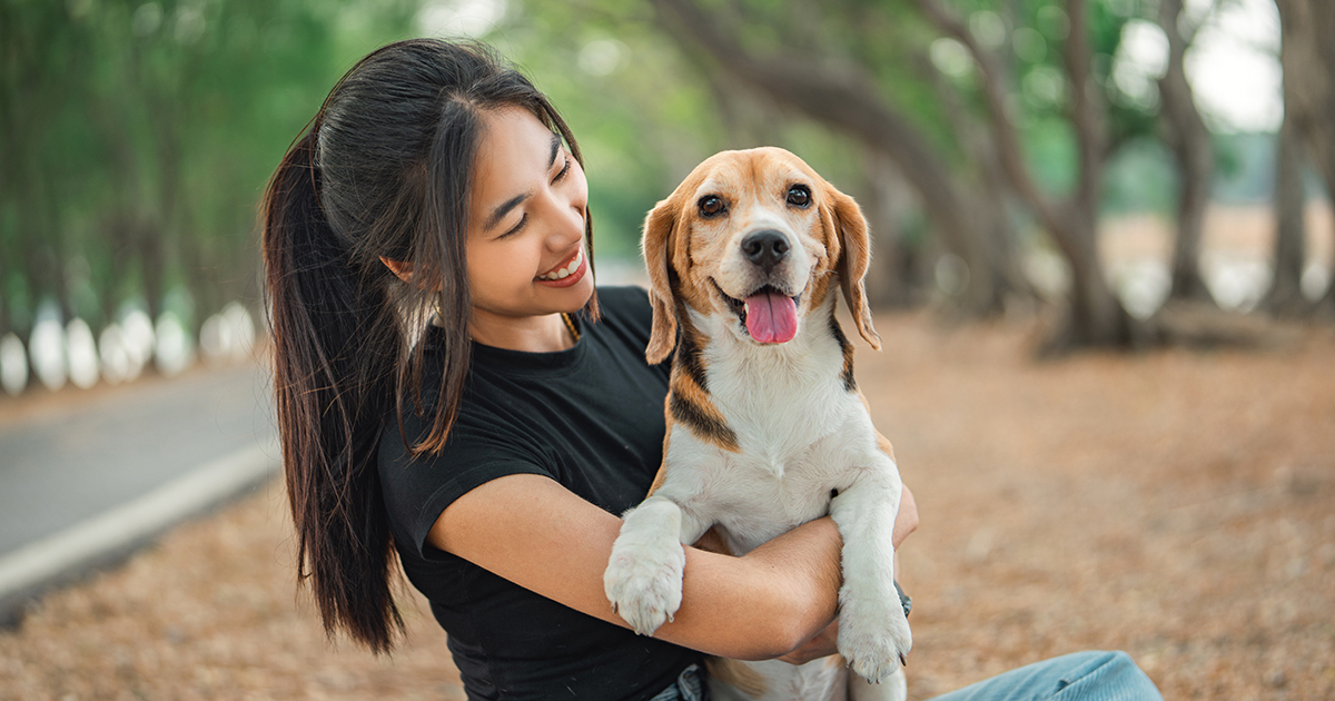 Woman smiles holding a beagle