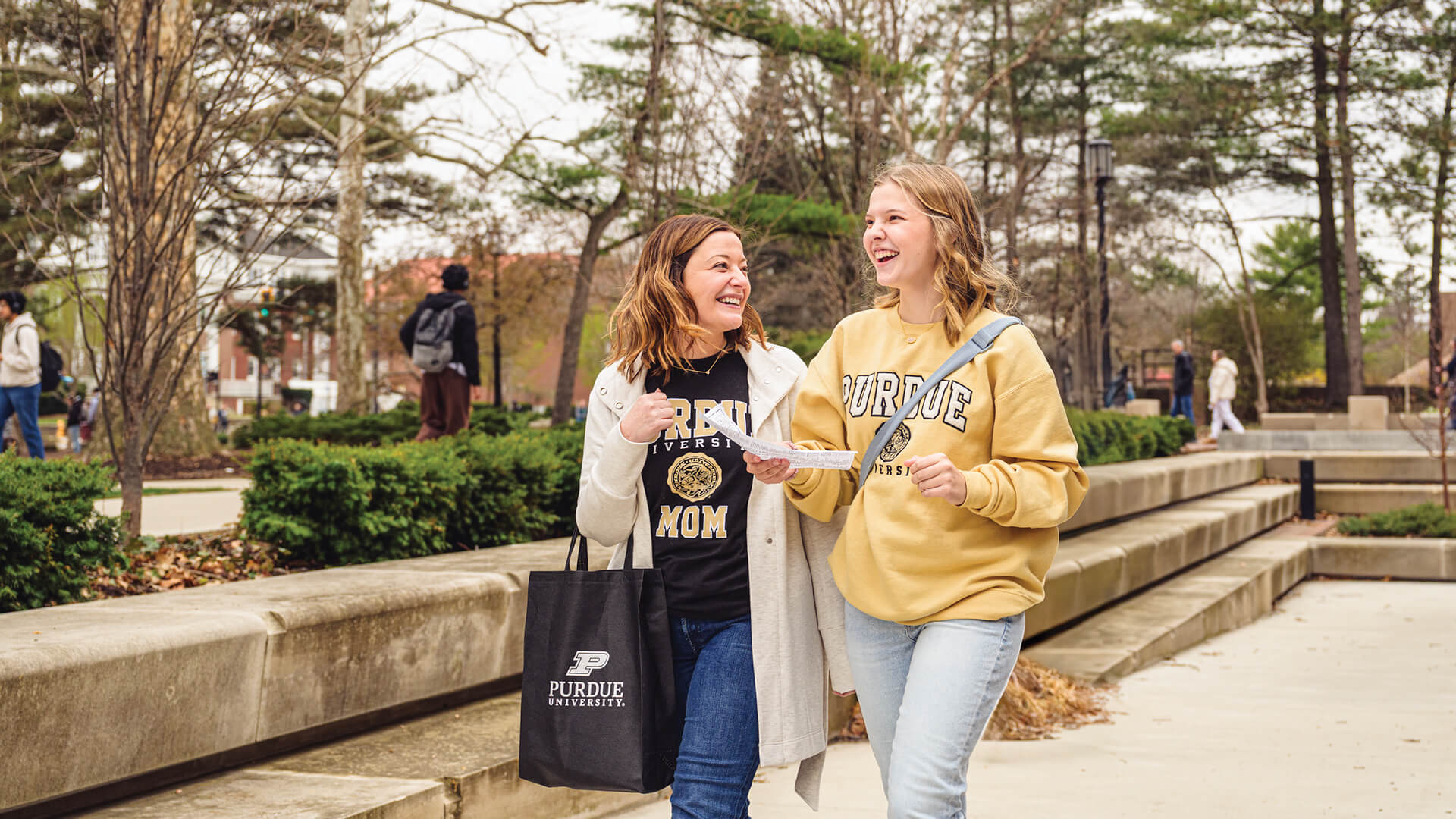 Student laughing with parent while walking on campus.