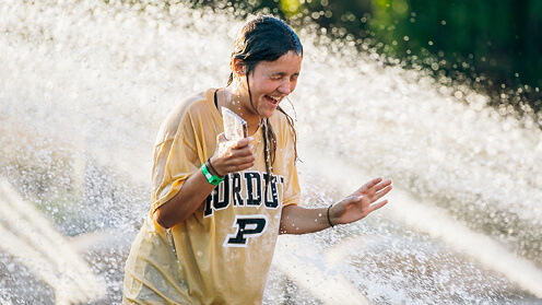 Student running through fountain.