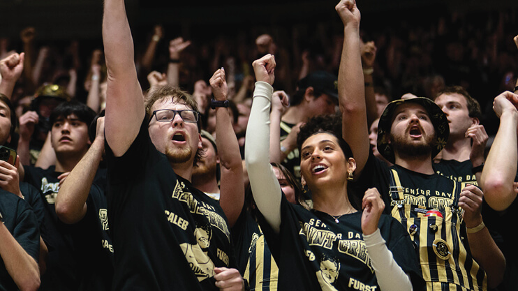 Students cheering at sporting event.