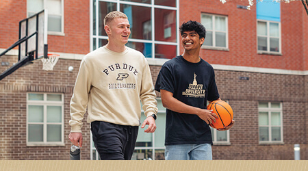 Students walking around an outdoor basketball court.