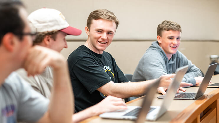 Students working on laptops in class.