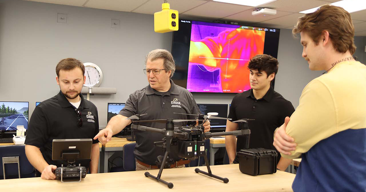 Students and a professor work on a drone
