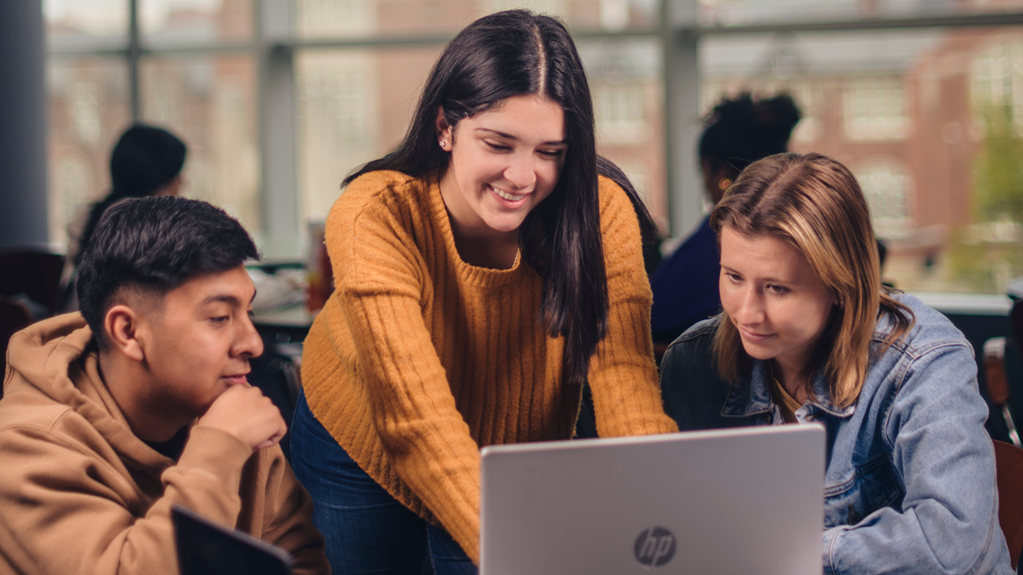 Three students work on a computer