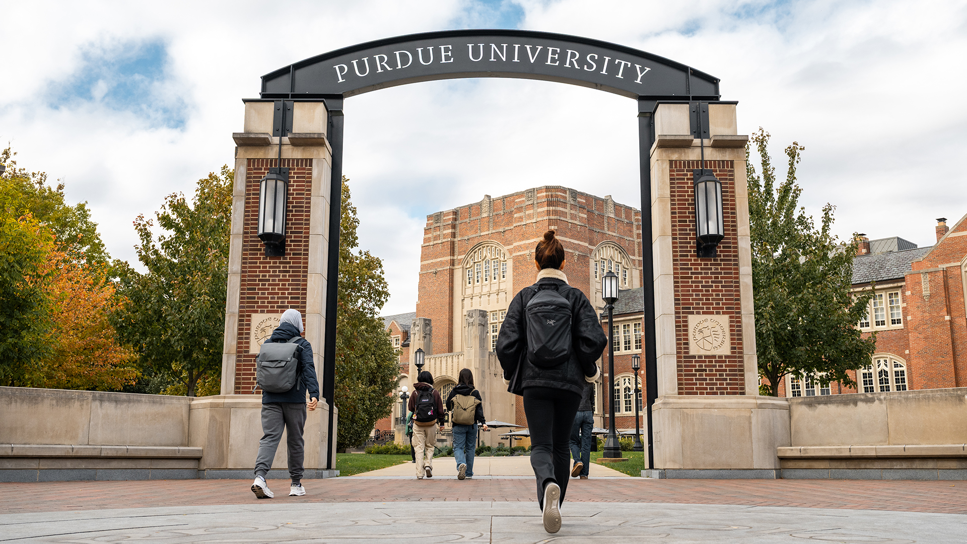 Students walk under an archway toward the Purdue Memorial Union