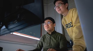 A student and parent look at a computer