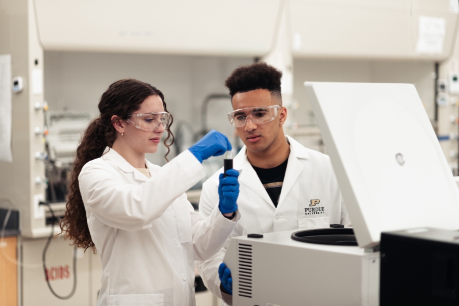 A student and instructor examine a sample together in a lab setting